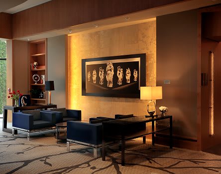 A modern lobby featuring a seating area with contemporary furniture, ambient lighting, and artistic wall decor.