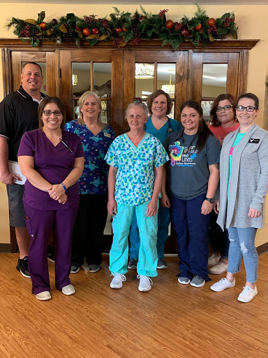 A dedicated healthcare team posing together in a warm setting.