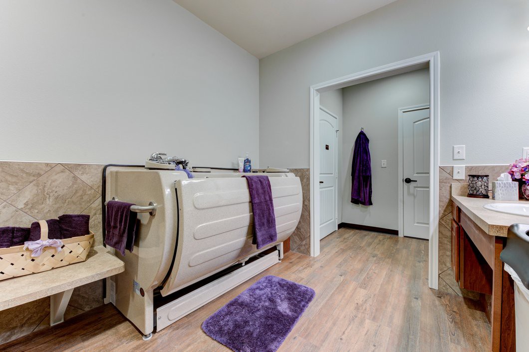A modern bathroom featuring a unique bathtub and purple accents.