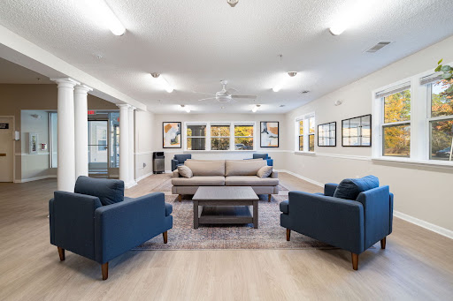 A cozy lounge area featuring modern furniture and ample natural light.