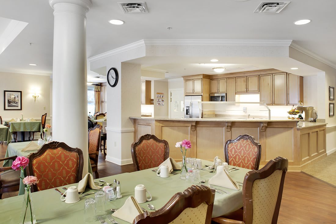 A well-lit kitchen and dining area with elegant furniture and a neatly set table.