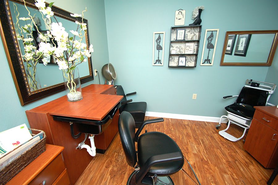 A cozy salon interior with styling chairs, a mirror, and decorative elements.