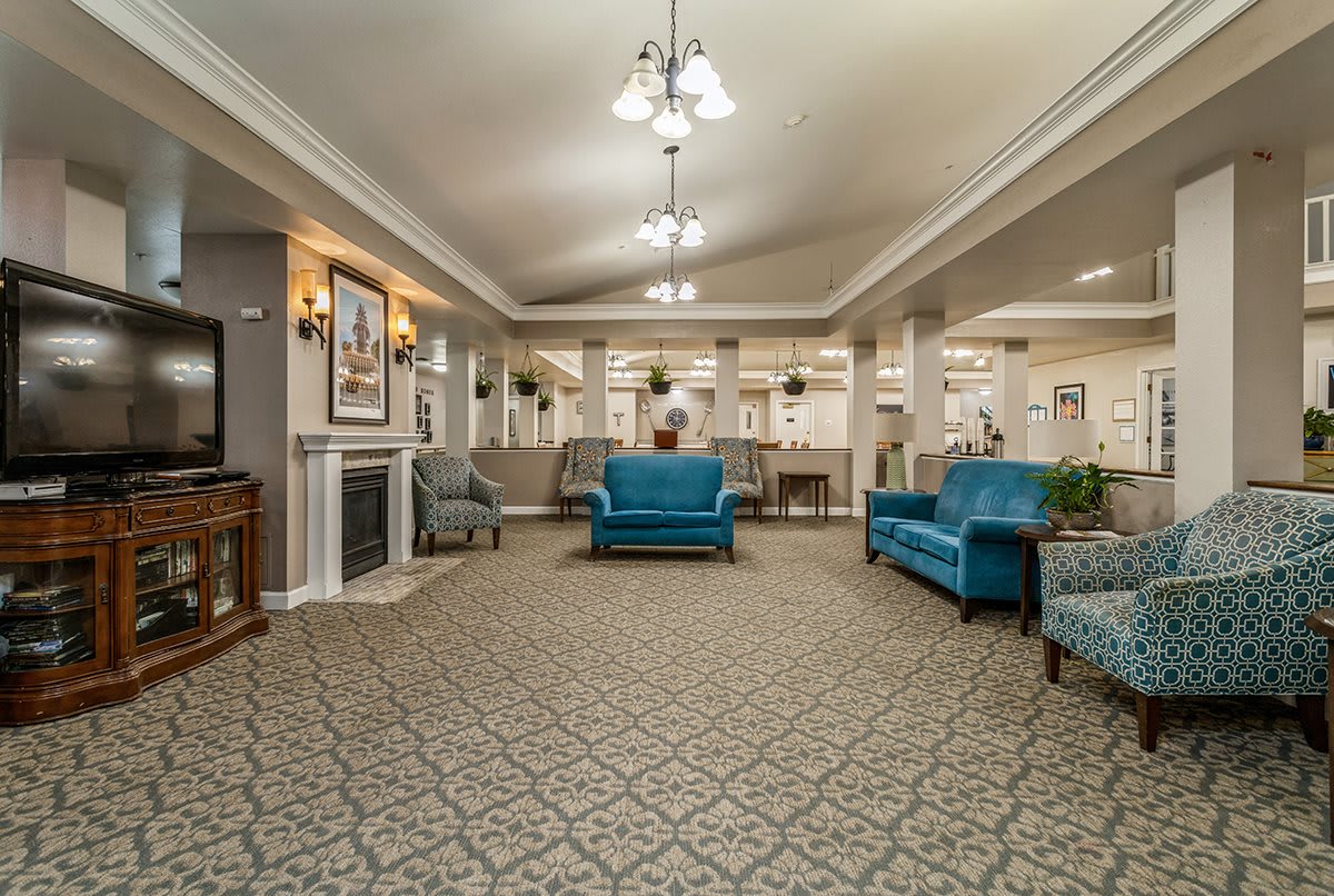 A well-decorated lobby area with blue sofas and elegant lighting.