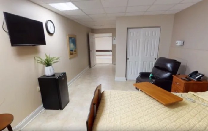 A minimalist room interior with a bed, chair, and wall decor.