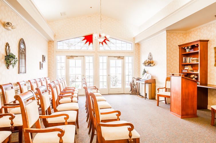 A bright room with neatly arranged chairs and large windows.