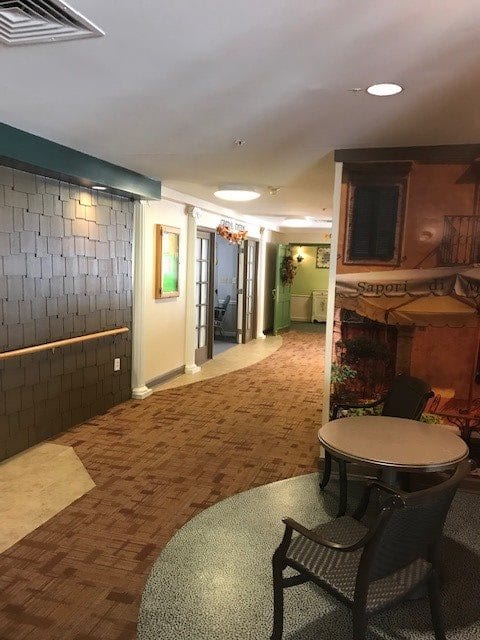 A cozy hallway with carpeted flooring and seating area.