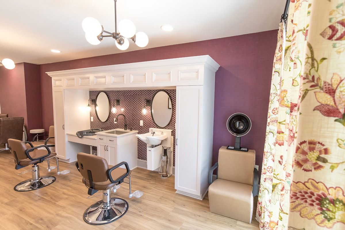 A modern beauty salon interior with styling stations and mirrors.