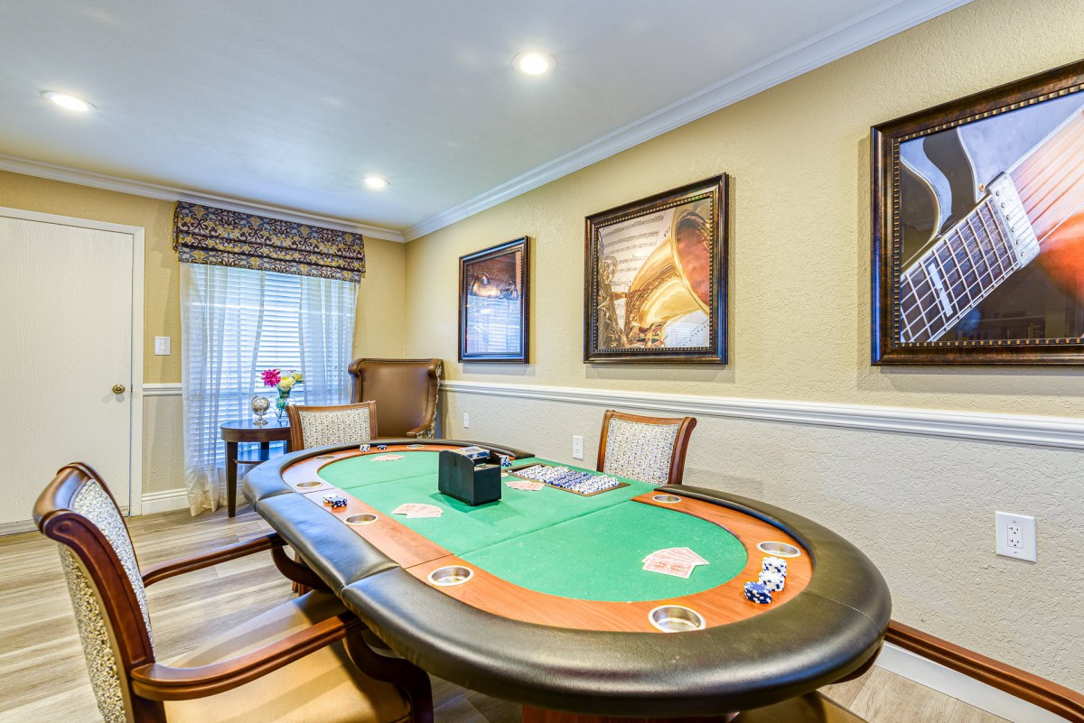 A luxurious room featuring a poker table with elegant decor and artwork on the walls.