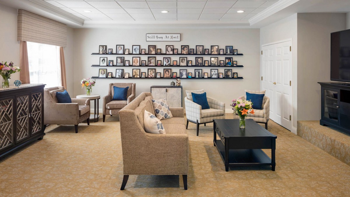 A cozy waiting area with plush seating and a wall of framed photos.