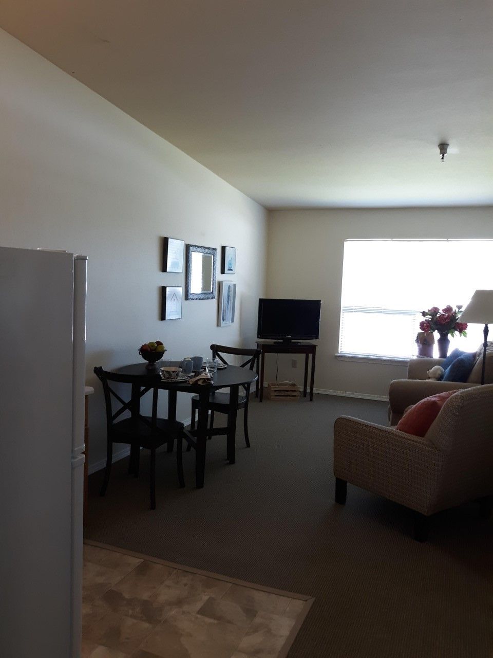 A cozy apartment living room with a small dining area and a television.