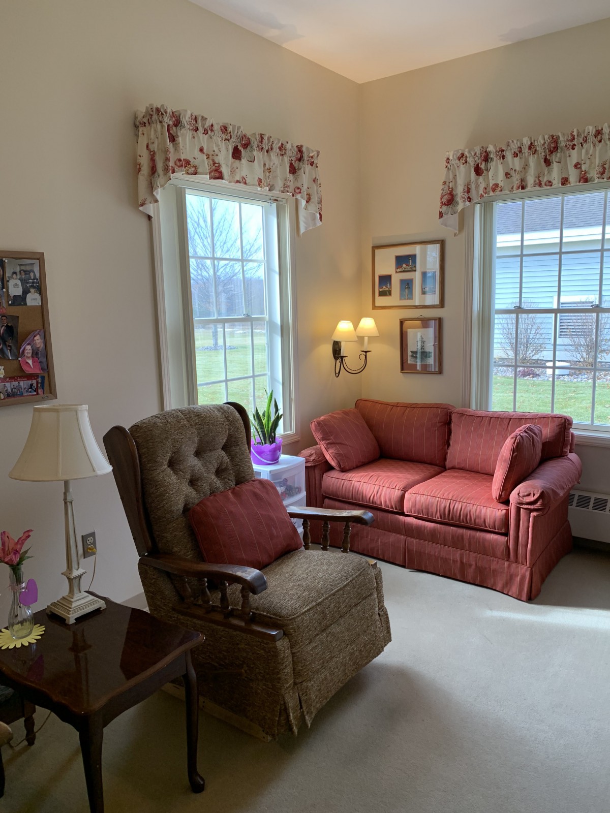 Cozy living room with an armchair and sofa next to large windows.