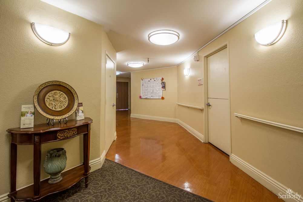 A well-lit hallway with doors and decorative furniture.