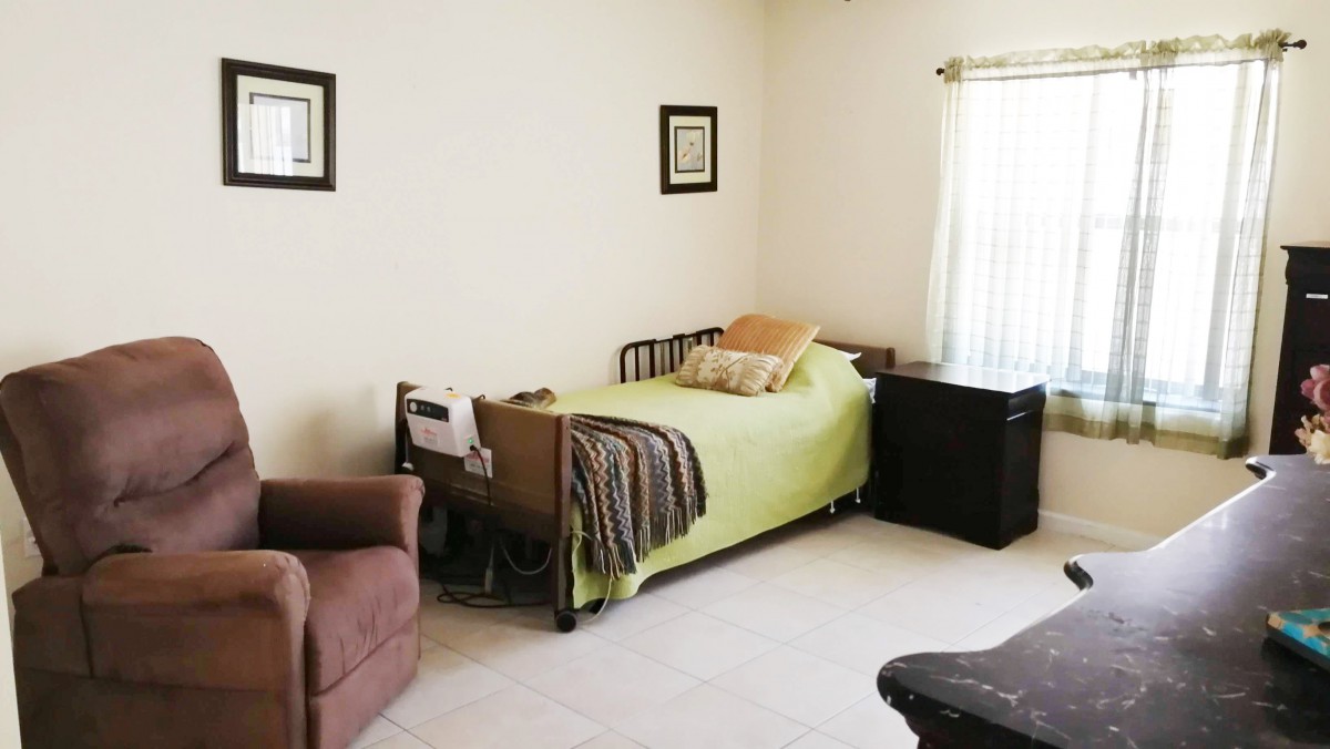A simple and cozy bedroom with a single bed, a chair, and minimalist decor.