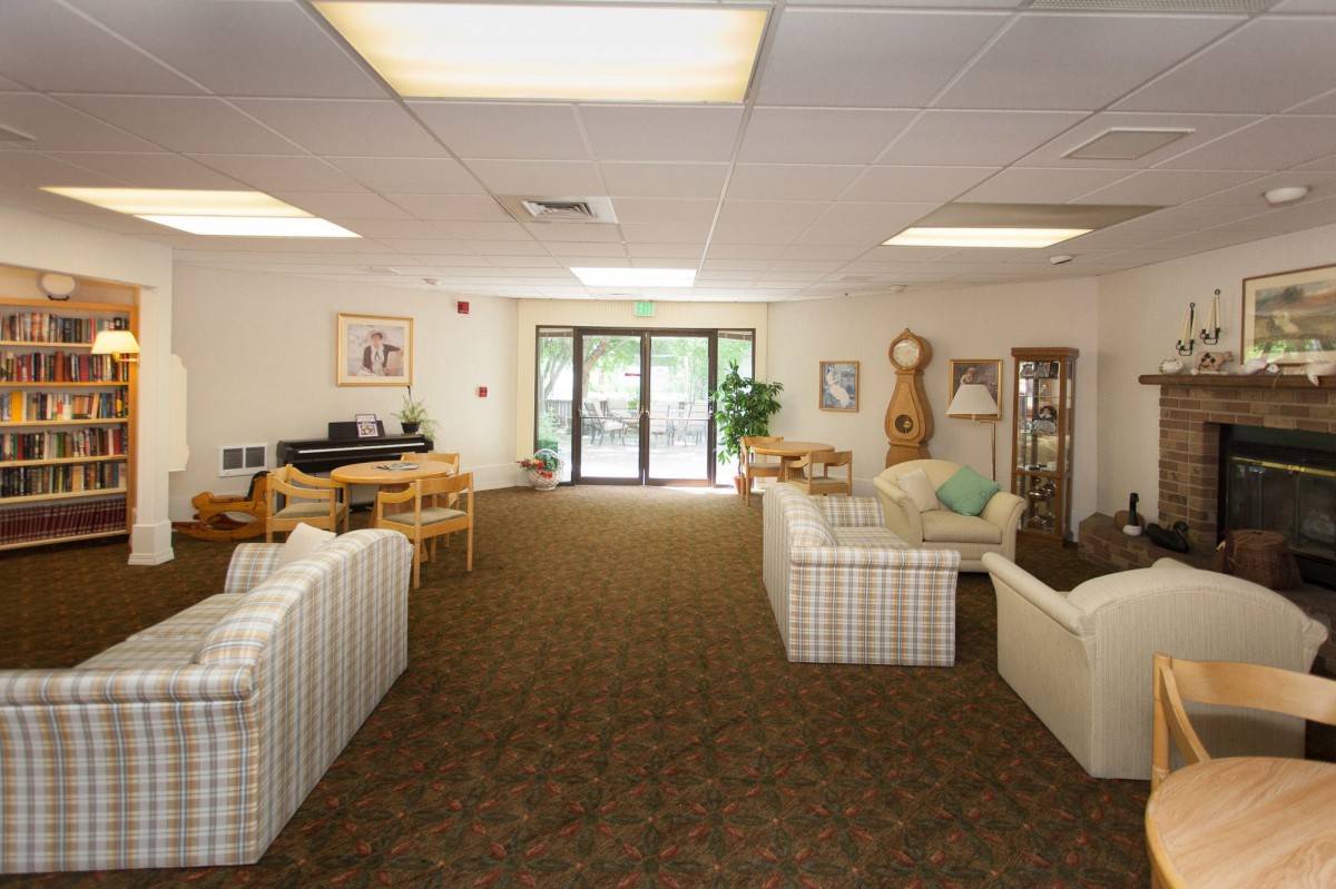 A spacious living room with sofas, a coffee table, and large windows allowing natural light.