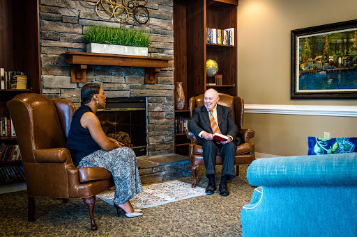 Two individuals engaged in conversation in a cozy living room setting.