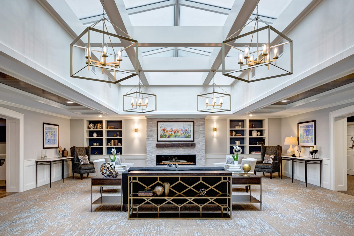 A luxurious and modern living room featuring elegant chandeliers, a skylight, and sophisticated decor.