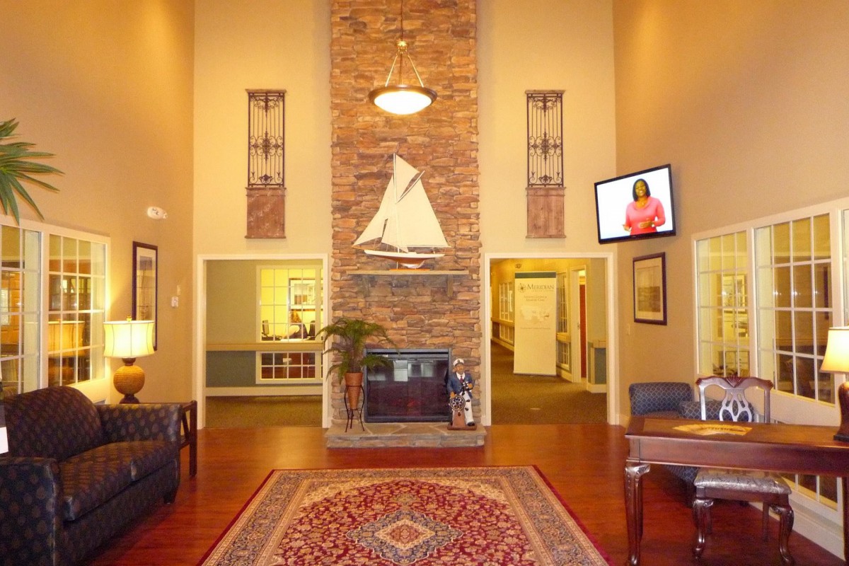A well-decorated lobby with a fireplace, decorative ship model, and comfortable seating.