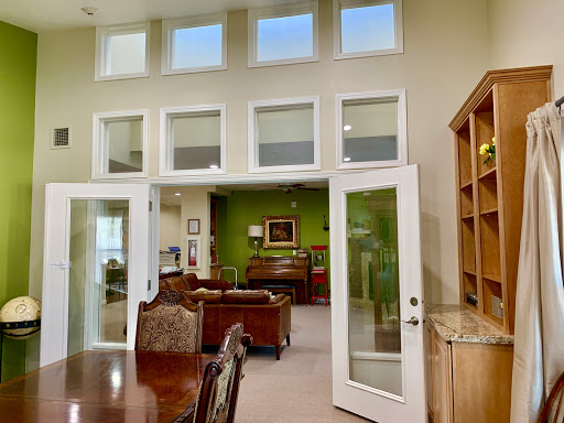 A spacious living area showcasing a blend of natural light and refreshing green decor.