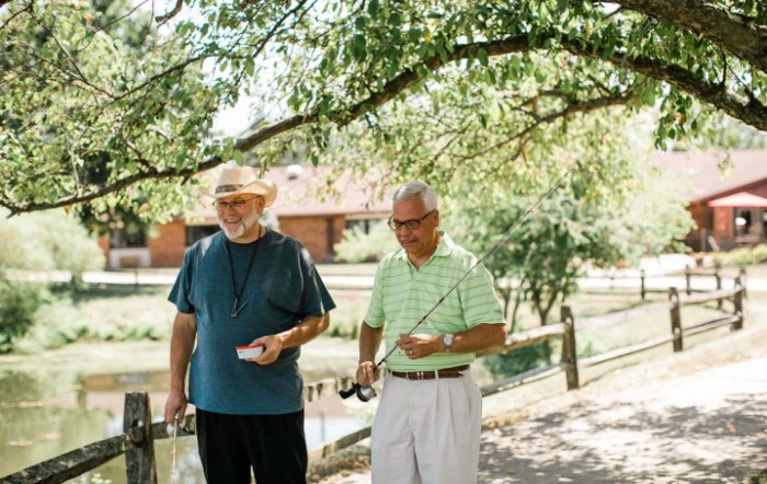 Two men enjoying a sunny day outdoors with fishing gear.