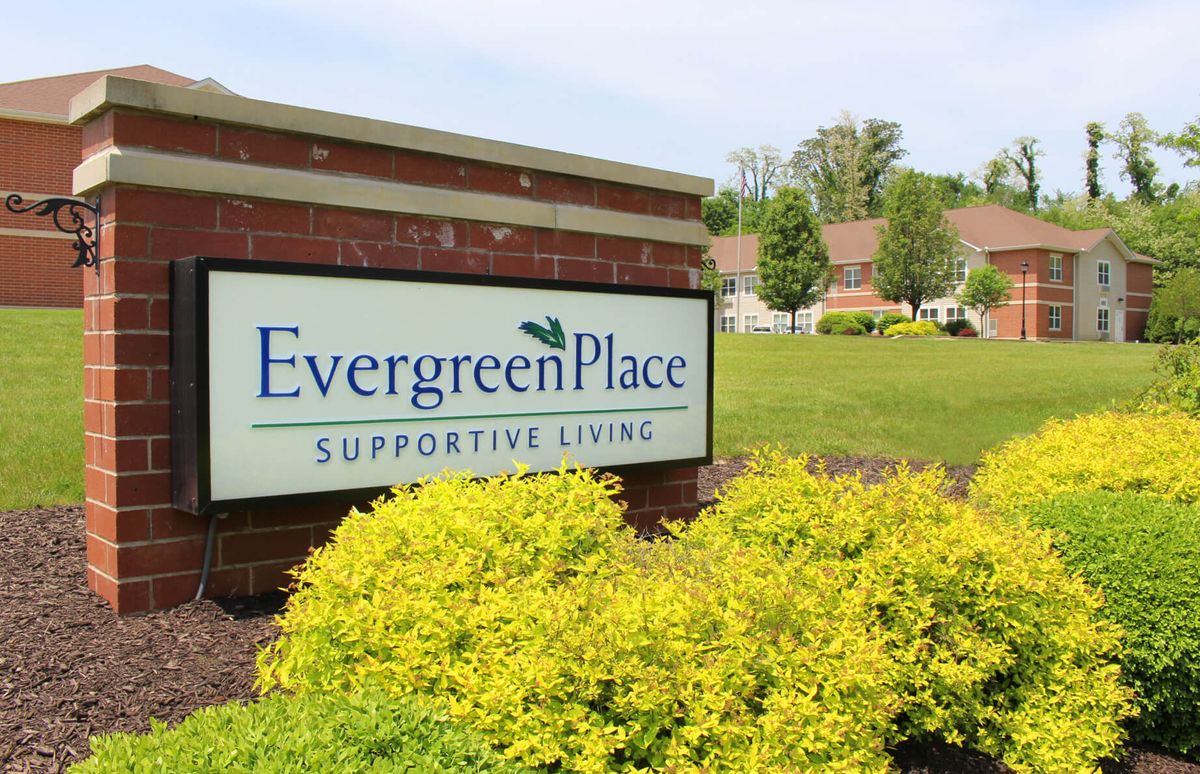 Sign for Evergreen Place Supportive Living in a landscaped outdoor setting.