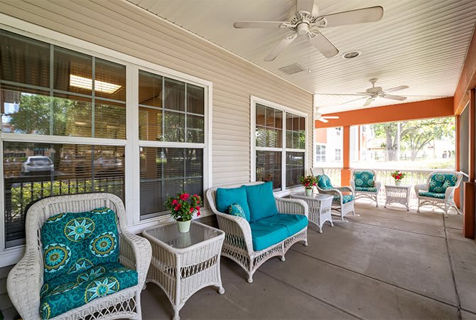 A cozy patio area with wicker furniture and bright cushions, perfect for relaxation.