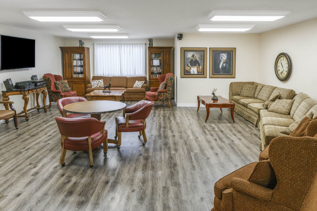 A cozy living room with comfortable seating, featuring sofas, chairs, and tables on a hardwood floor.