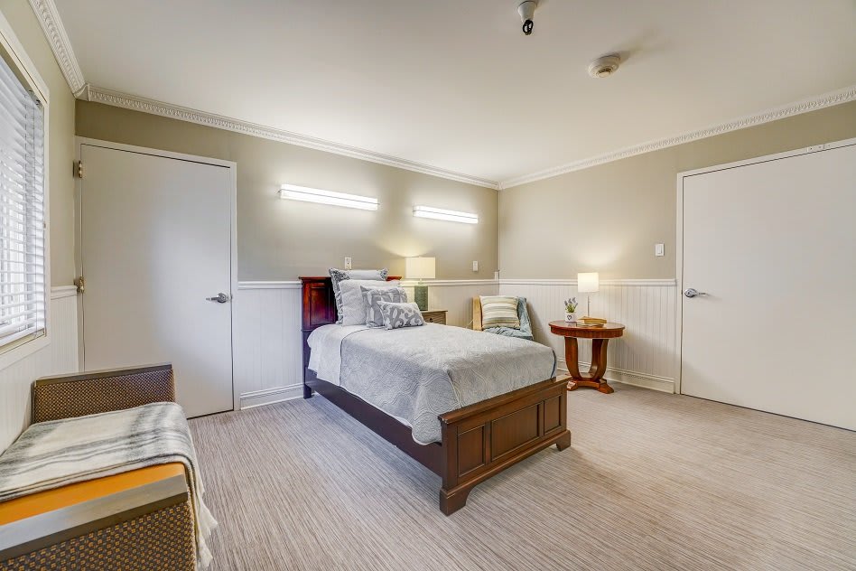 A cozy bedroom with a single bed, two side tables, and warm lighting.