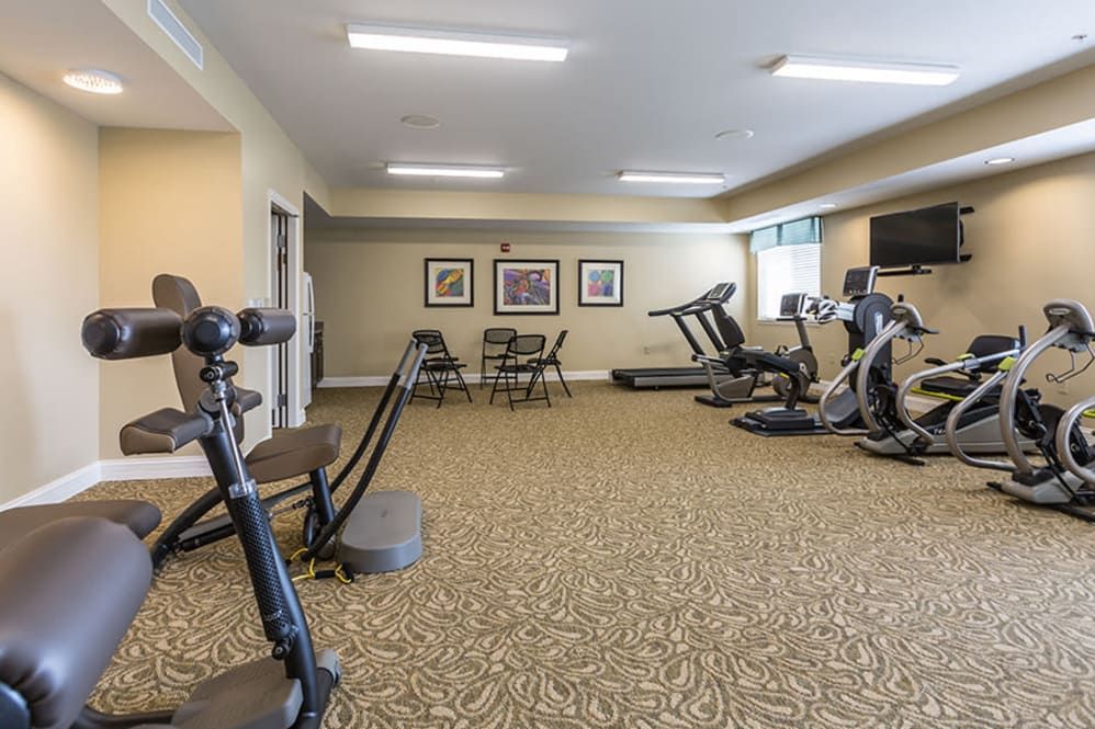 A well-equipped indoor gym with various exercise machines including treadmills and a stationary bike.