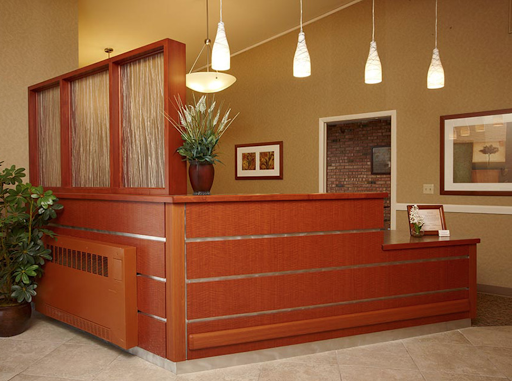A modern reception area featuring wooden furniture and contemporary lighting.