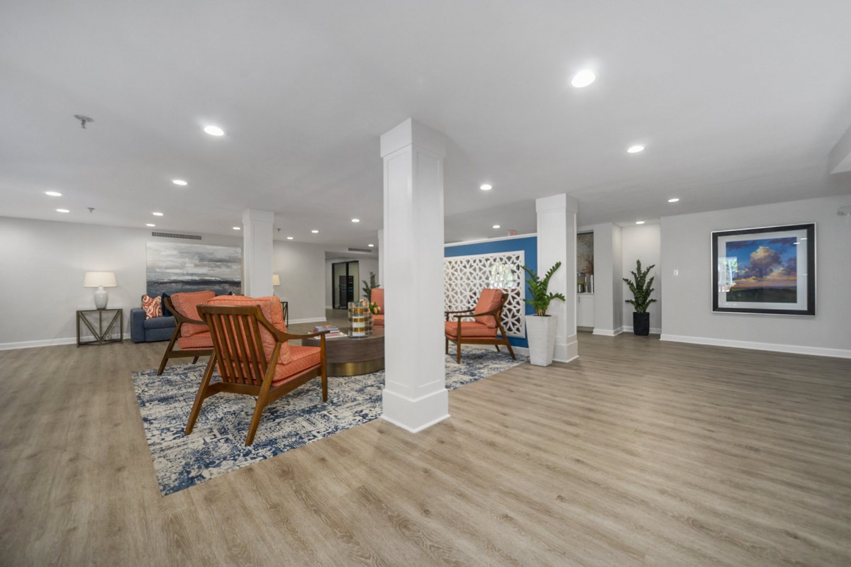 A modern living room with wooden floors, comfortable seating, and bright lighting.