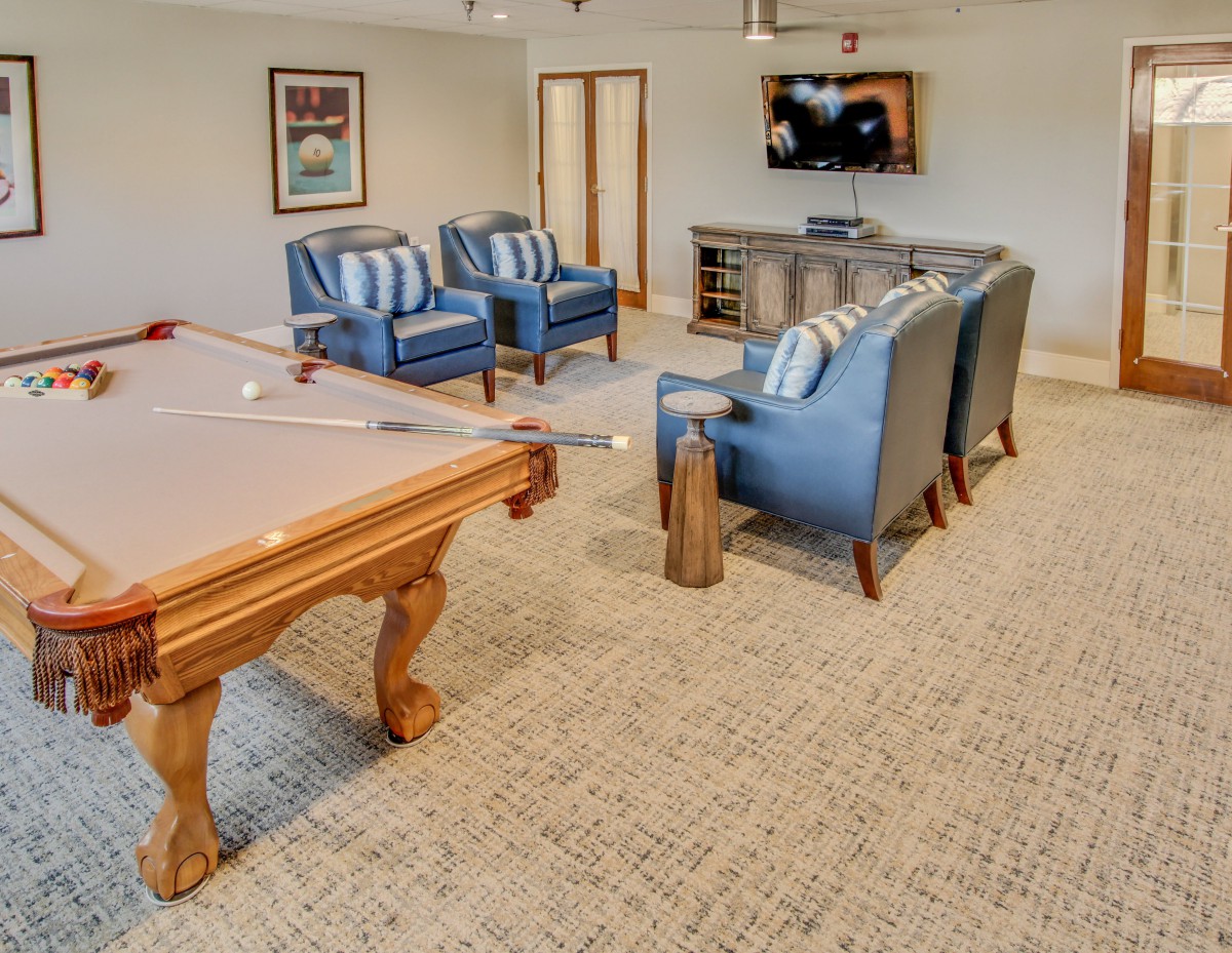 A cozy basement entertainment room with a pool table and comfortable seating.