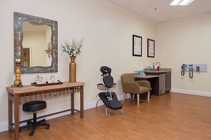 A cozy waiting area featuring a massage chair and stylish decor.