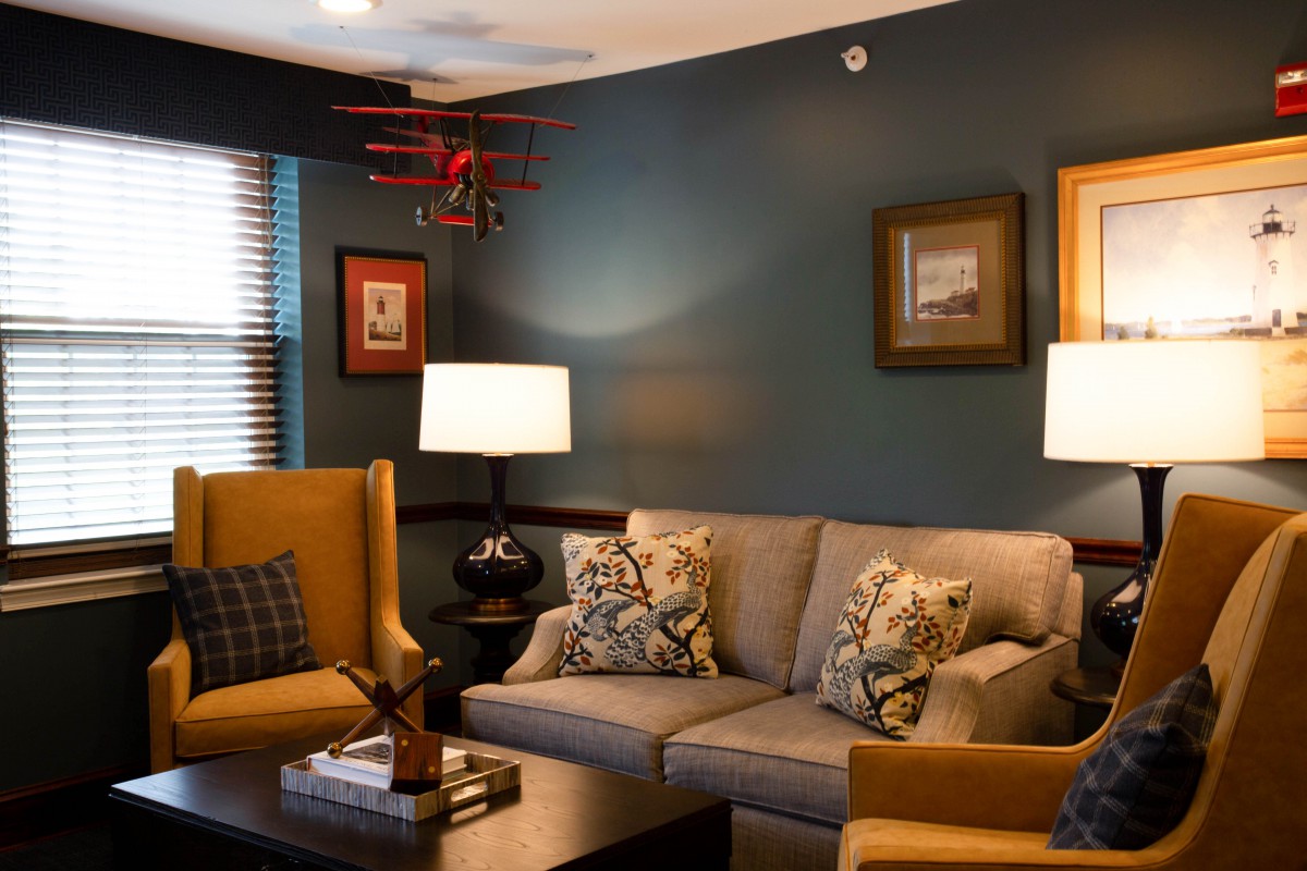 A cozy living room with vintage decor, featuring a comfortable sofa, armchairs, and ambient lighting.