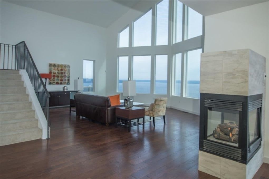 A modern living room with large windows offering a stunning ocean view.