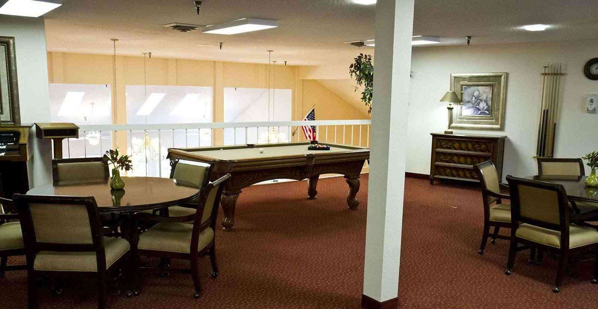 A recreation room with a pool table and seating area.