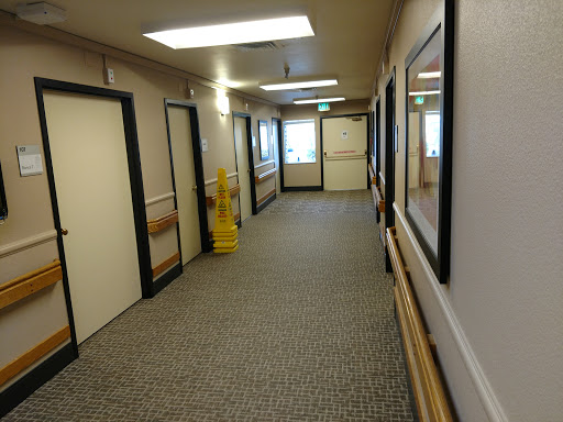 A well-lit and clean hallway featuring multiple doors and framed pictures.