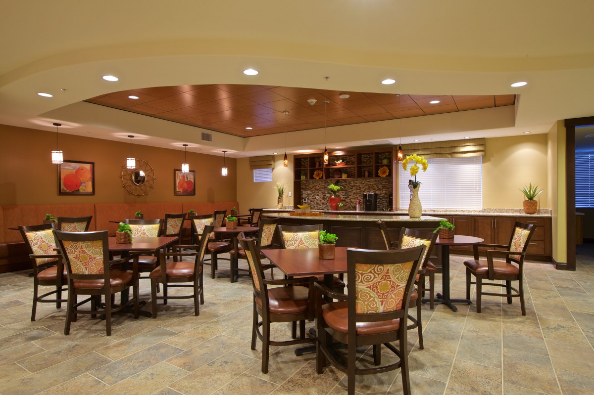 A cozy restaurant dining area with neatly arranged tables and chairs, warm lighting, and tasteful decor.