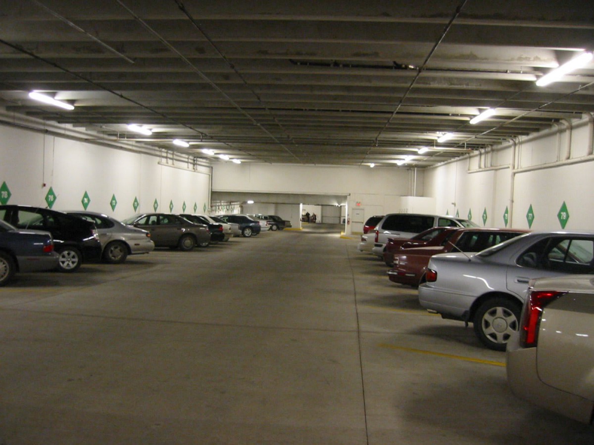An indoor parking lot with multiple parked cars and concrete flooring.