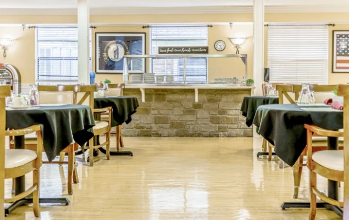 An empty dining area with neatly arranged tables and chairs, ready for service.