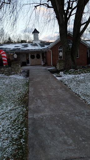 A cozy house adorned with winter decorations, surrounded by a light dusting of snow.