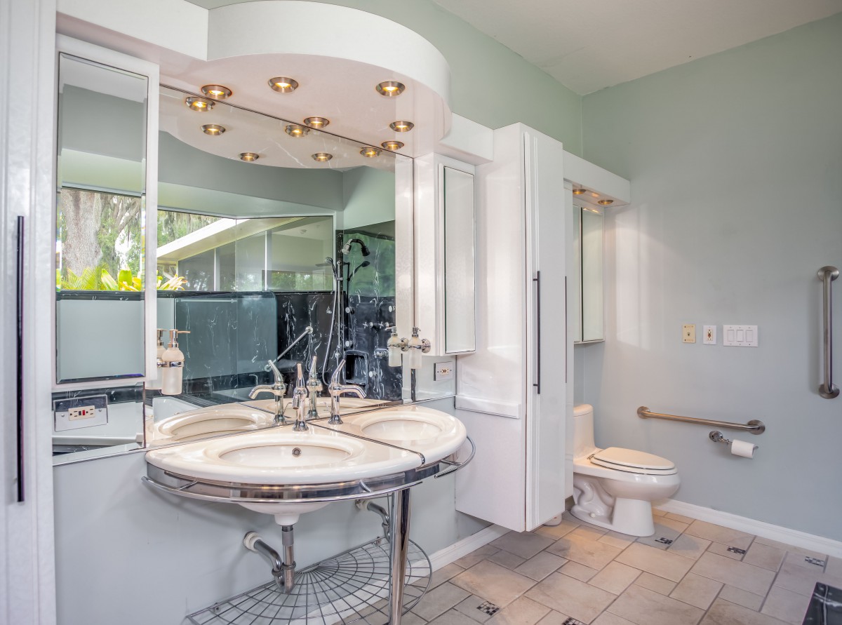 A modern bathroom with a stylish vanity, large mirror, and tiled flooring.