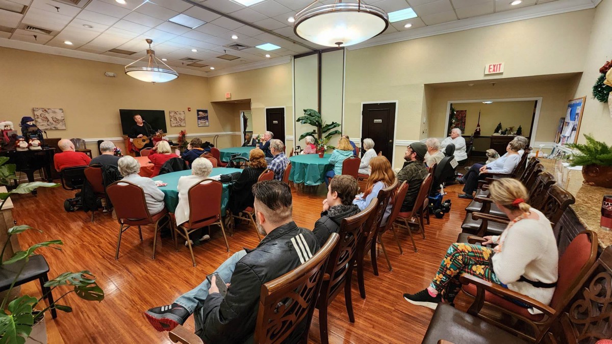 A group of people attending an indoor event, seated and listening attentively.