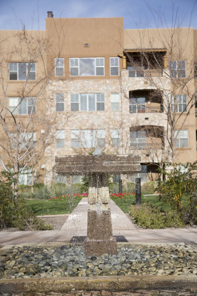 A courtyard with a fountain in front of a residential apartment building.