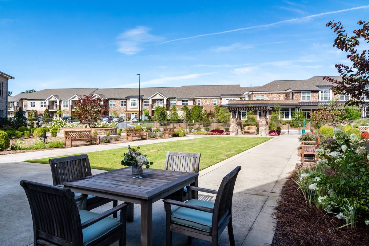 A charming residential garden with a patio set and well-maintained landscaping.