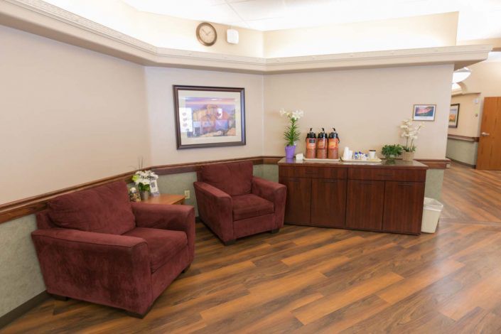 A cozy waiting room with comfortable chairs and a refreshment table.