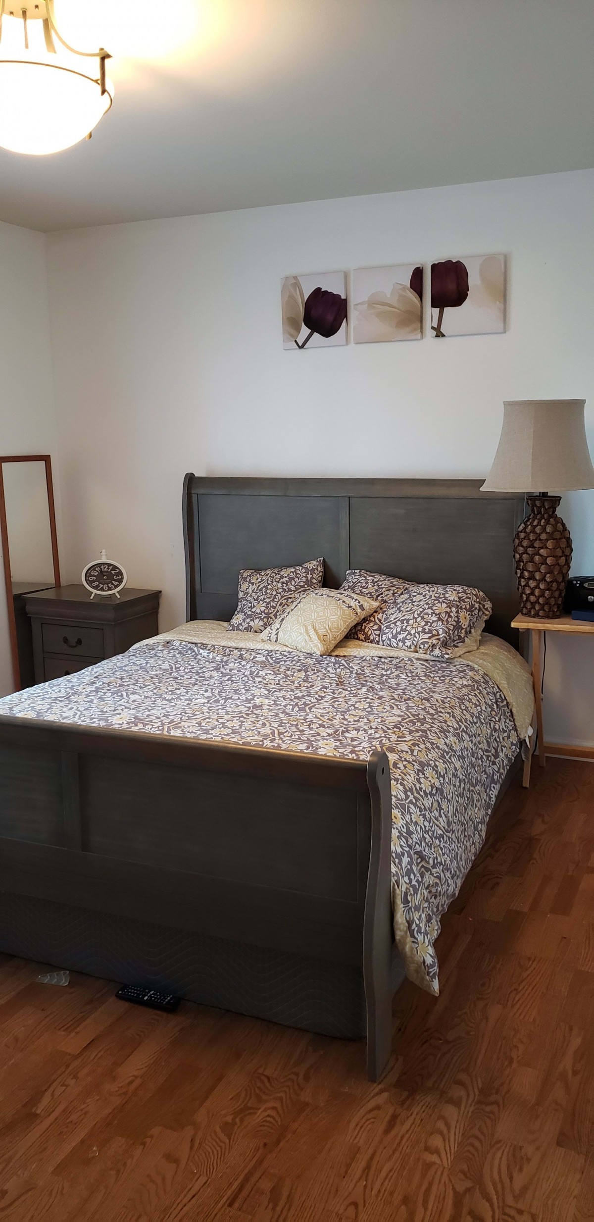 A cozy bedroom with a patterned bedspread and decorative pillows.