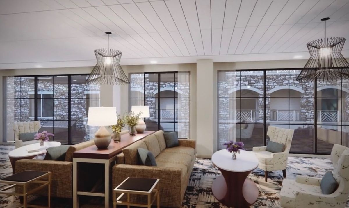 A stylish living room featuring comfortable seating, elegant lighting, and large windows.