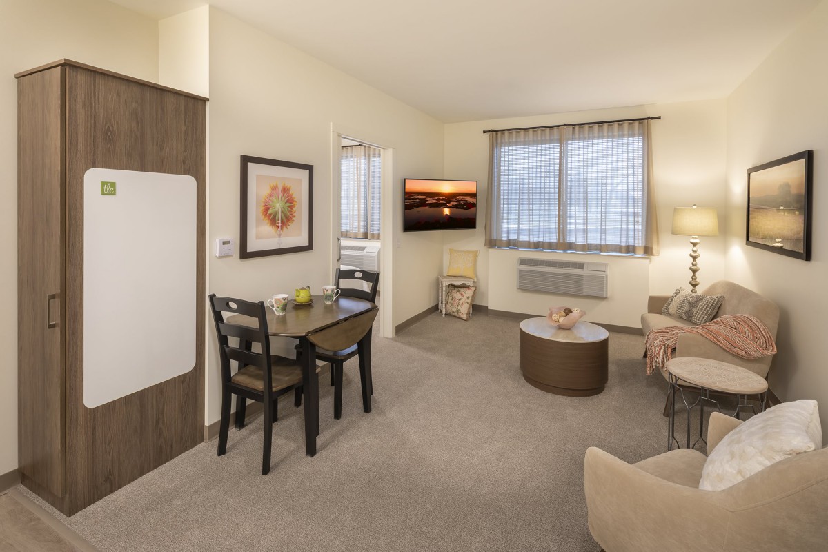A cozy apartment living room with a small dining area and modern decor.