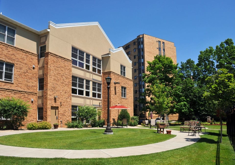 A view of a campus building with a landscaped garden and pathway.