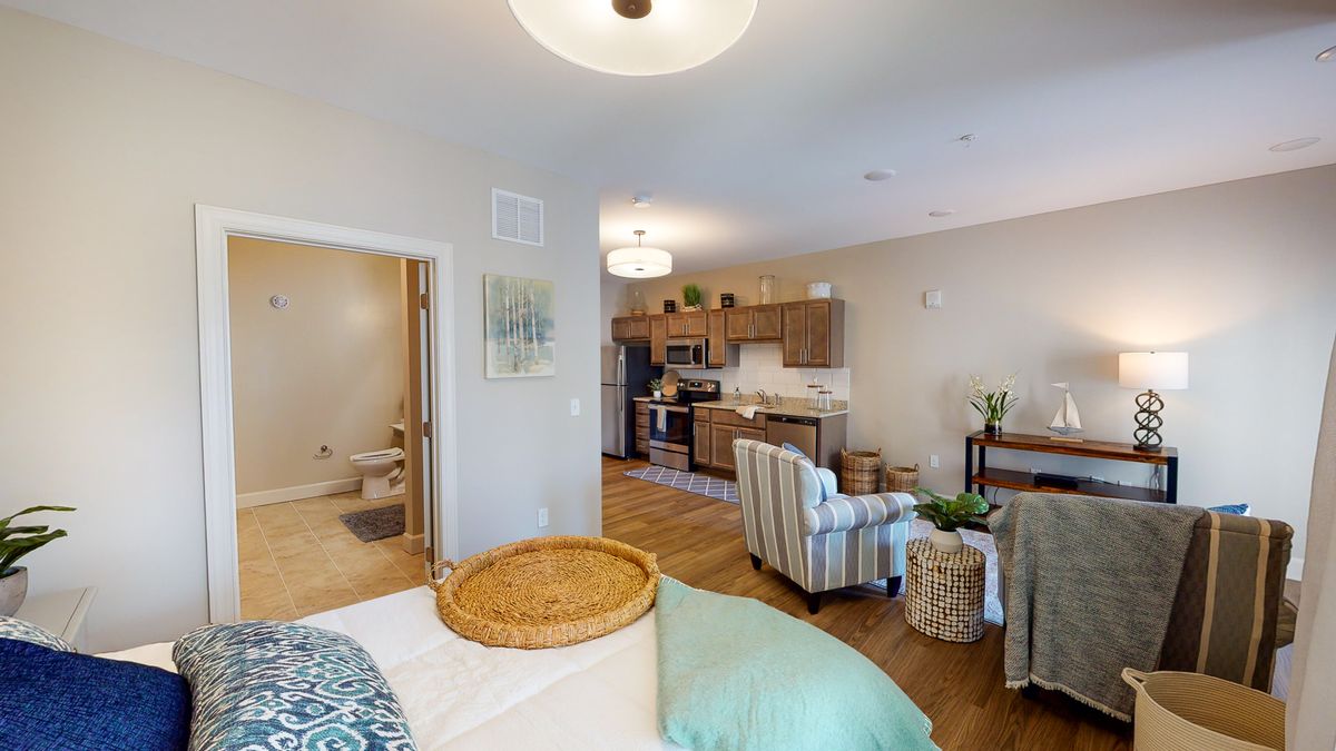 A modern, open-concept apartment featuring a cozy living room and kitchen area.